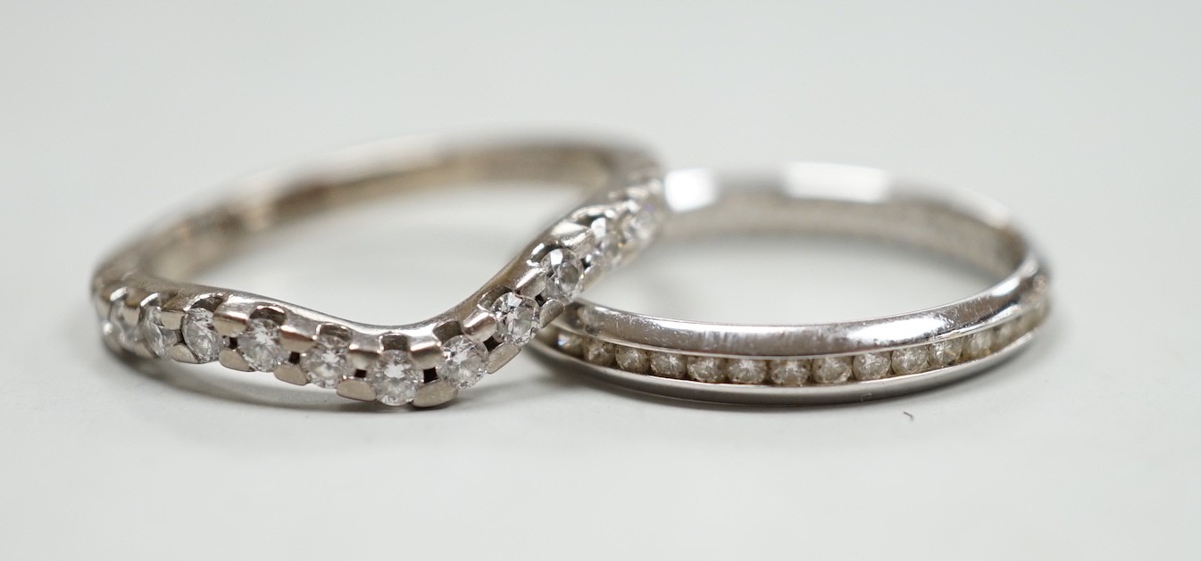 A modern 18ct white gold and diamond chip set full eternity ring, size O and a modern 18ct white gold and fourteen stone diamond chip set shaped half eternity ring, size O, gross weight 5.7 grams.